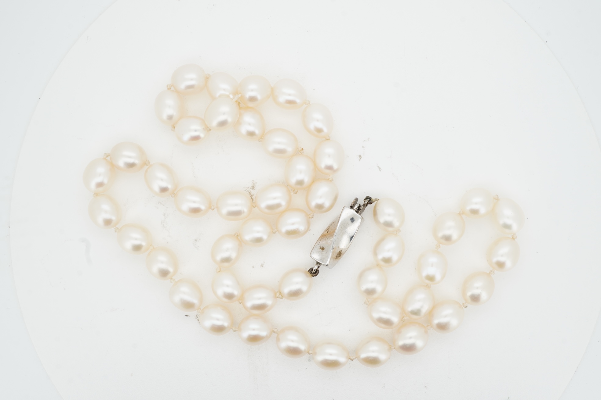 Tiffany & Co., a pair of diamond earrings and a cultured pearl necklace, the earrings of cross design, set with brilliant-cut diamonds totalling approximately 0.30 carats, mounted in platinum, length approximately 0.7cm